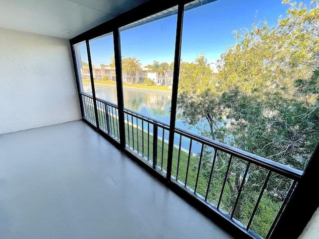 unfurnished sunroom featuring a water view