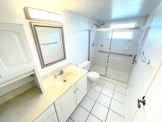 bathroom featuring tile patterned flooring, a shower stall, toilet, and vanity