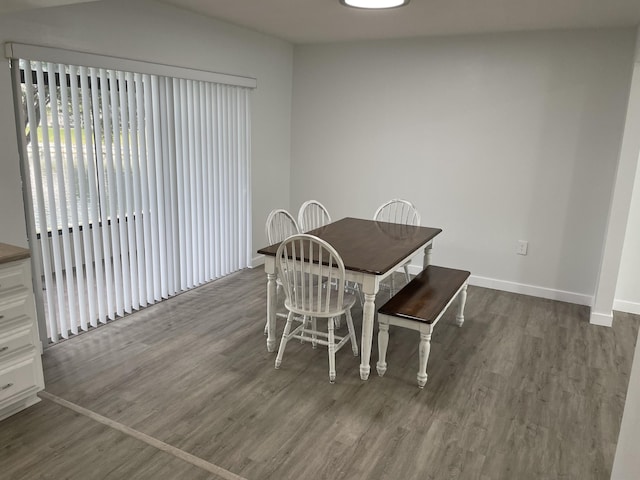 unfurnished dining area featuring baseboards and dark wood-type flooring