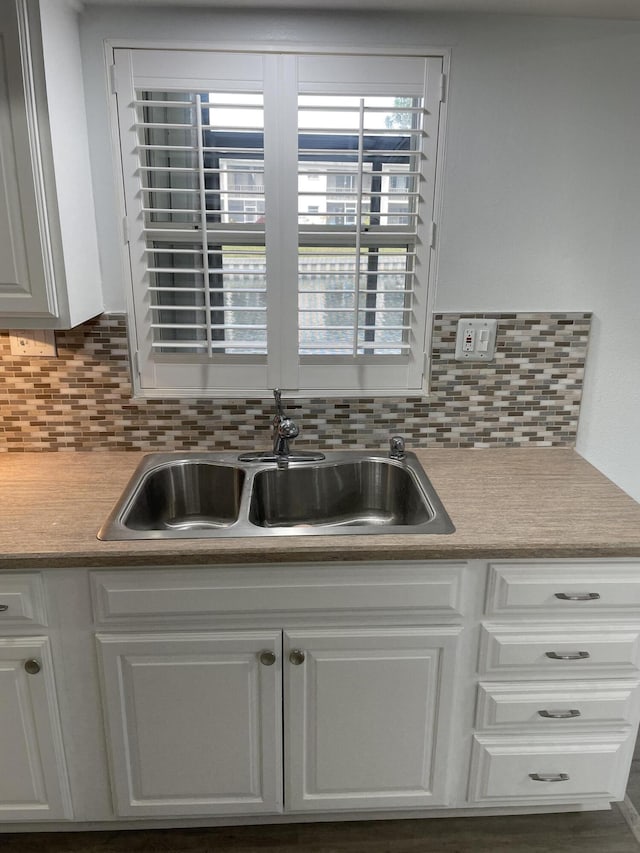 kitchen with white cabinetry, sink, and backsplash