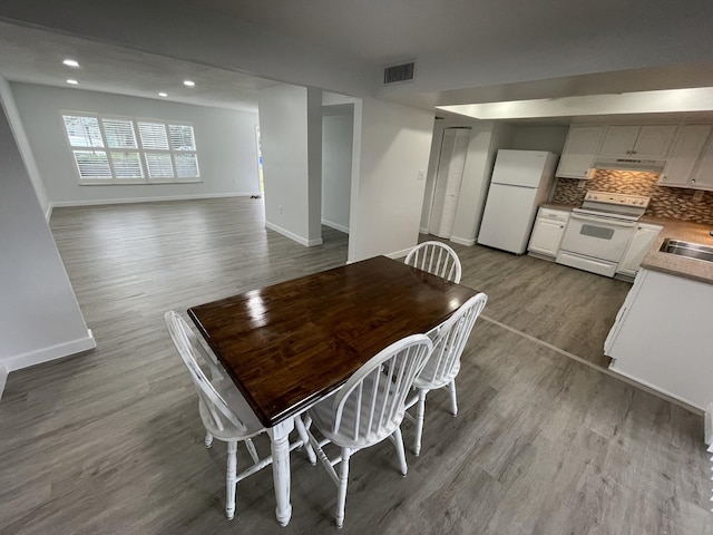 dining area featuring baseboards, visible vents, dark wood-style flooring, and recessed lighting