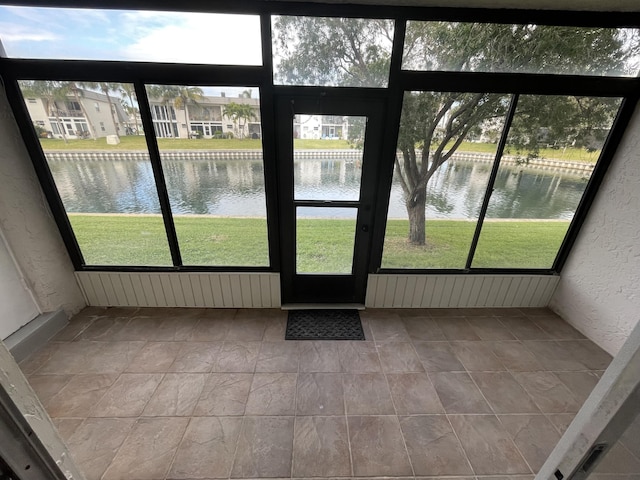 unfurnished sunroom with a water view