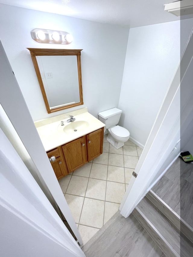 bathroom featuring vanity, tile patterned floors, and toilet