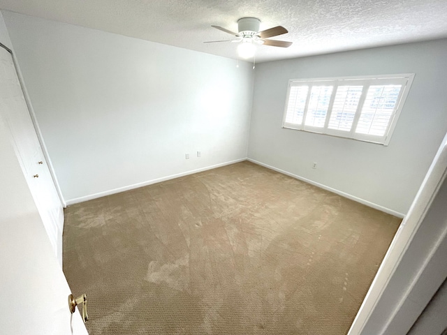 unfurnished room with ceiling fan, carpet floors, and a textured ceiling