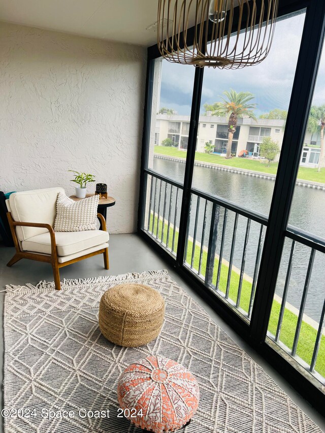 sunroom / solarium featuring a wealth of natural light and a water view