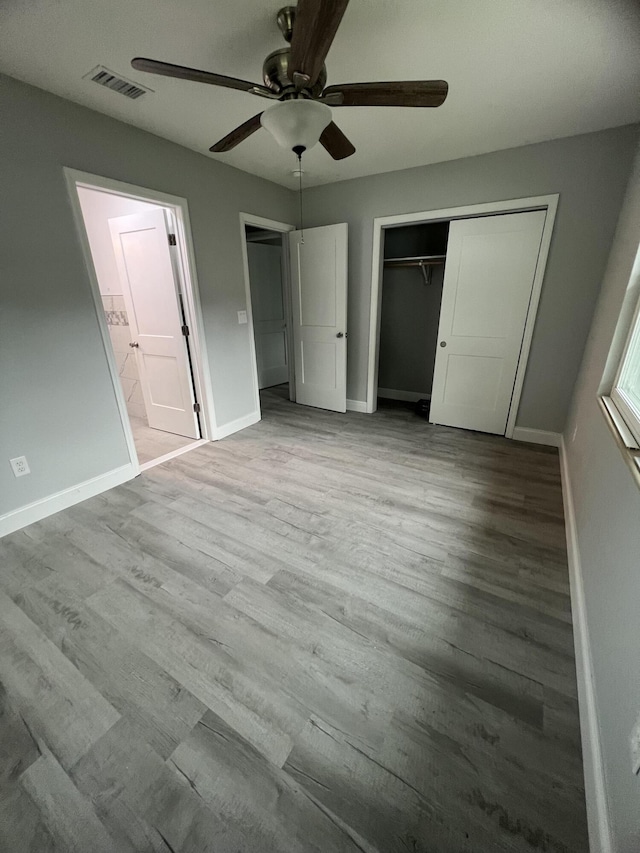 unfurnished bedroom featuring ceiling fan, light hardwood / wood-style floors, and a closet