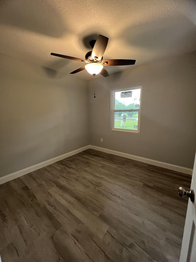 unfurnished room with ceiling fan, a textured ceiling, and dark hardwood / wood-style flooring