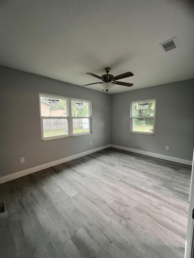 unfurnished room featuring ceiling fan, plenty of natural light, and light hardwood / wood-style floors