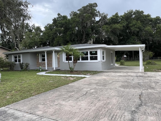 view of front of home with an attached carport, concrete driveway, and a front yard