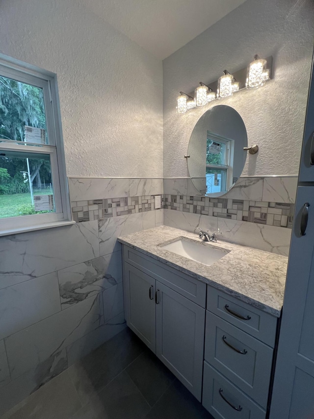 bathroom with vanity and tile walls