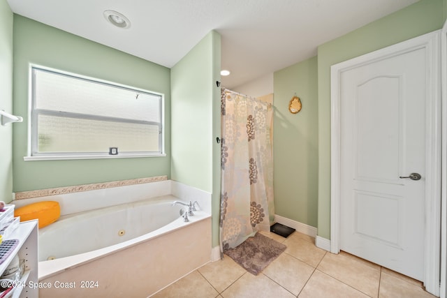 bathroom featuring plus walk in shower, tile patterned flooring, and a healthy amount of sunlight