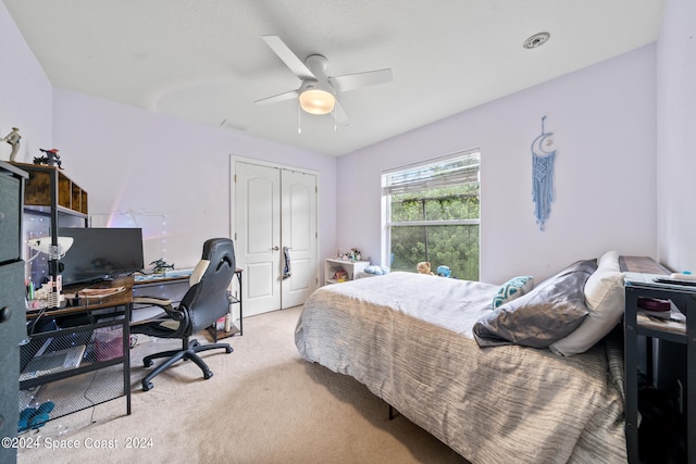 bedroom featuring ceiling fan, light carpet, and a closet