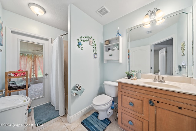 bathroom with toilet, vanity, and tile patterned floors