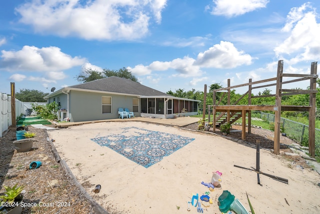 rear view of house featuring a patio and a sunroom