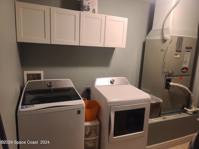 washroom with independent washer and dryer and cabinets