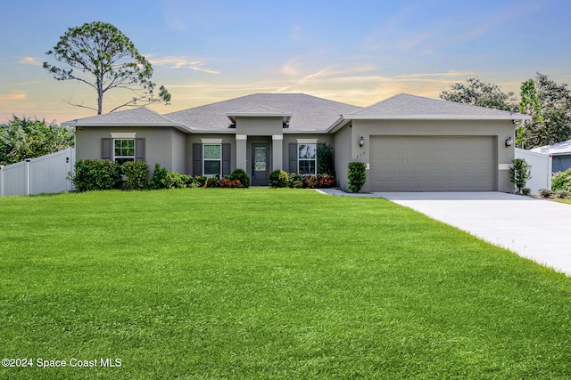 view of front of house featuring a yard and a garage