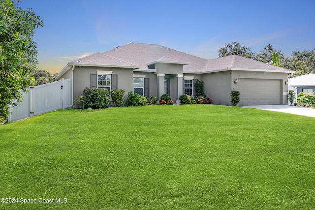 view of front of home with a yard and a garage