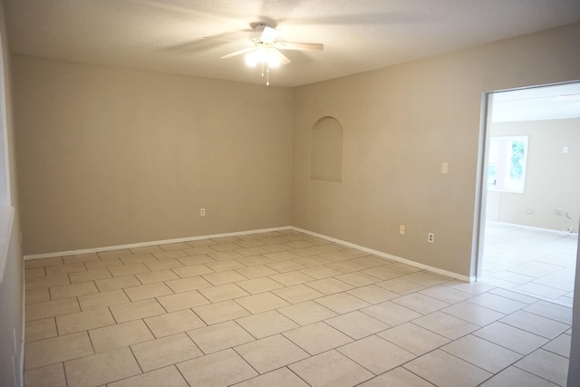 tiled spare room featuring ceiling fan