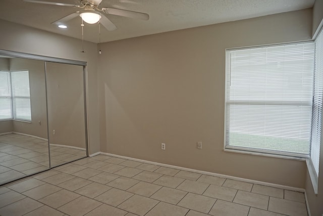 unfurnished bedroom featuring light tile patterned floors, ceiling fan, and a closet