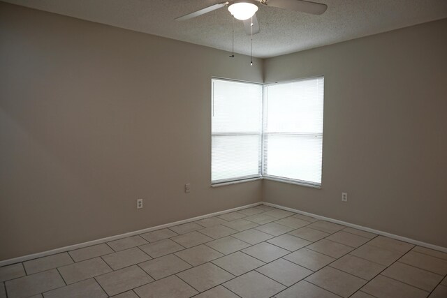 tiled empty room with a textured ceiling and ceiling fan