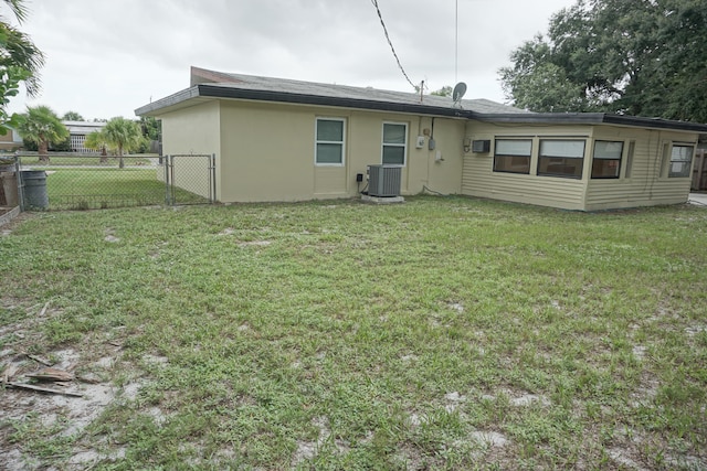 rear view of house featuring a yard and central air condition unit