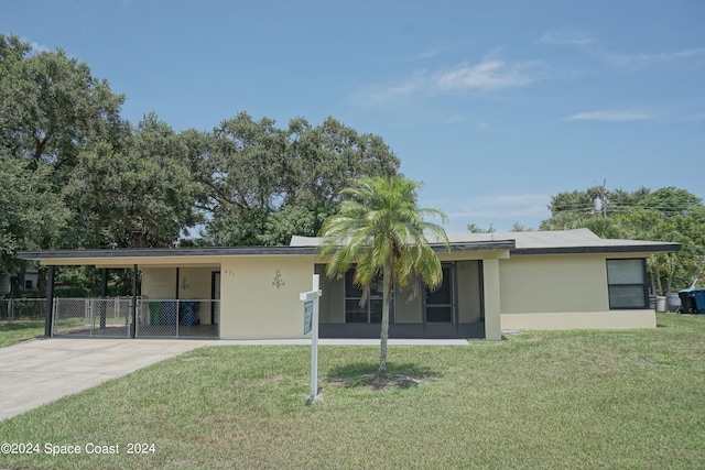 ranch-style home featuring a front lawn and a carport