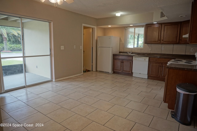 kitchen featuring a textured ceiling, white appliances, light tile patterned floors, sink, and ceiling fan