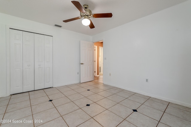 unfurnished bedroom featuring light tile patterned flooring, ceiling fan, and a closet