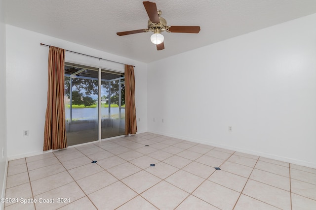 tiled empty room with a textured ceiling and ceiling fan