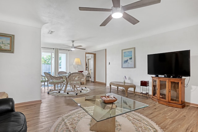 living room with light wood-type flooring and ceiling fan