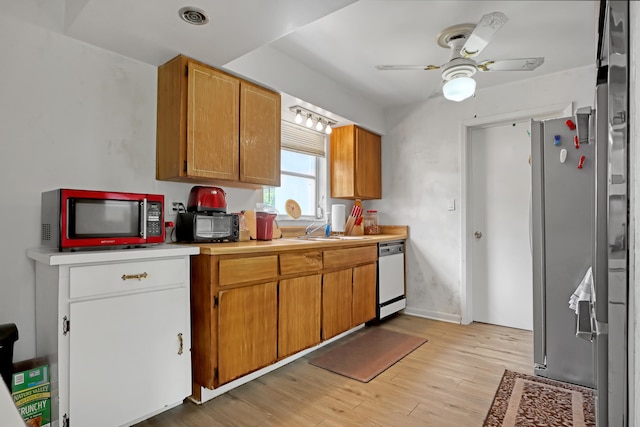 kitchen featuring light hardwood / wood-style flooring, appliances with stainless steel finishes, sink, and ceiling fan