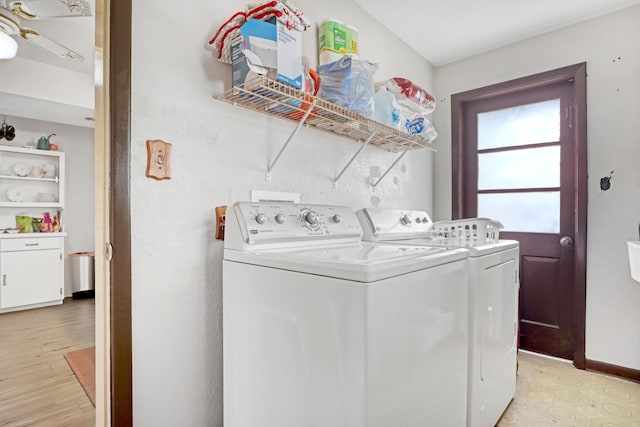 clothes washing area with separate washer and dryer and light wood-type flooring