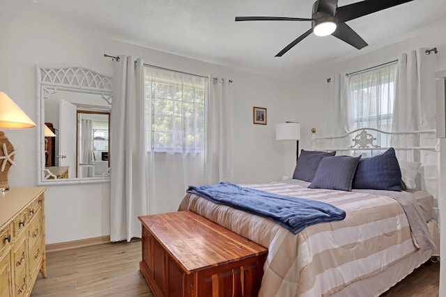 bedroom featuring multiple windows, ceiling fan, and light wood-type flooring