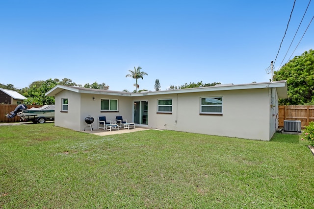 rear view of property with a patio, cooling unit, and a yard