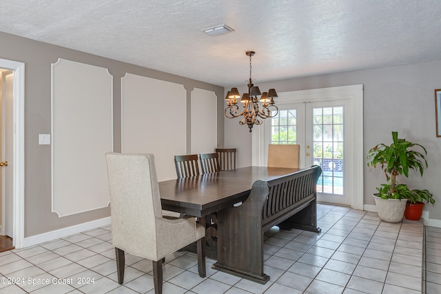 dining space featuring french doors, a textured ceiling, a notable chandelier, and light tile patterned floors