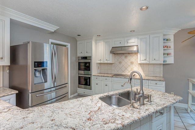 kitchen with sink, appliances with stainless steel finishes, light stone counters, and white cabinets