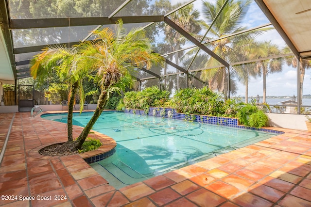 view of swimming pool featuring a patio and a lanai