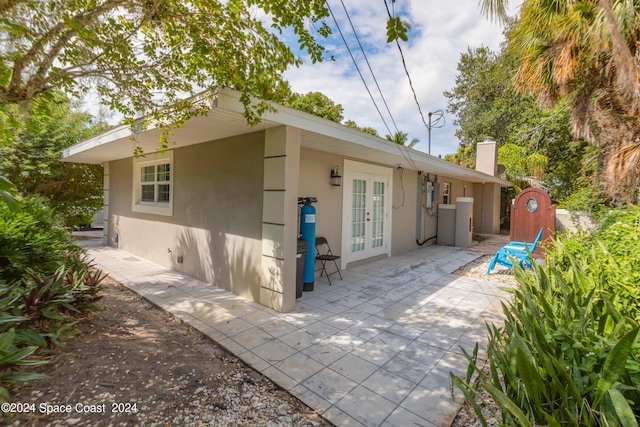 back of property with an outdoor structure, french doors, and a patio area