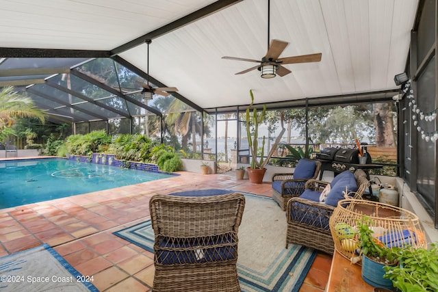 view of swimming pool featuring a patio, glass enclosure, and ceiling fan