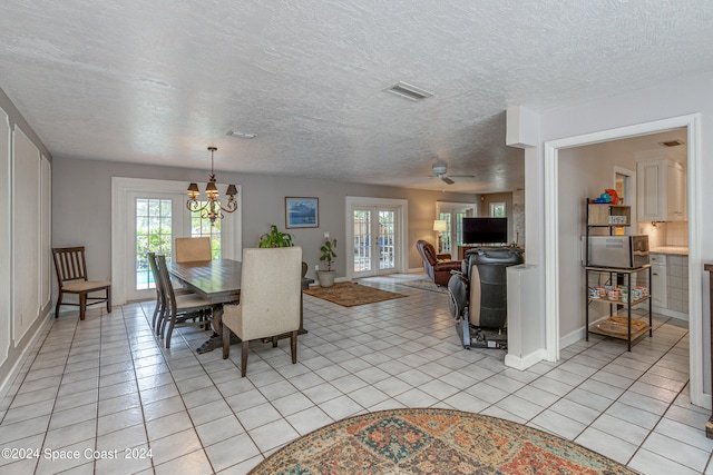 dining room featuring ceiling fan with notable chandelier, plenty of natural light, and light tile patterned floors