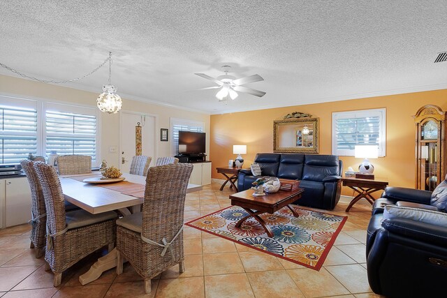 dining space featuring ornamental molding, a textured ceiling, and light tile patterned floors