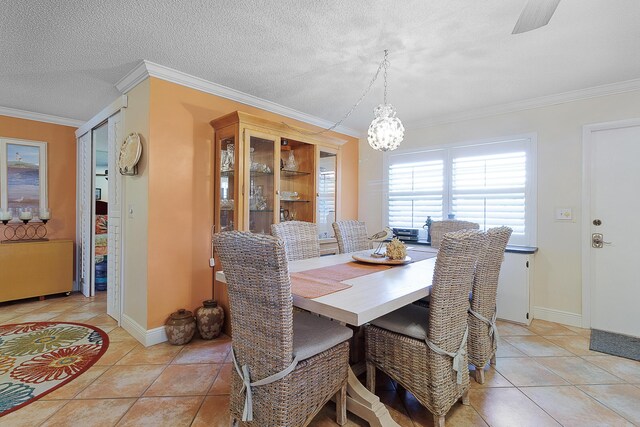 dining room with light tile patterned floors, crown molding, a textured ceiling, and a chandelier