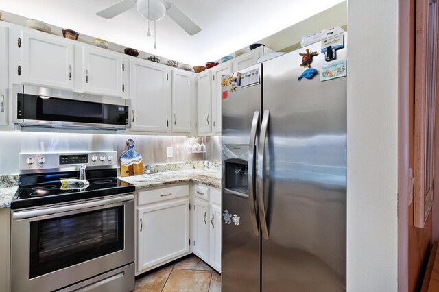 kitchen featuring white cabinetry, stainless steel appliances, light stone countertops, and light tile patterned floors