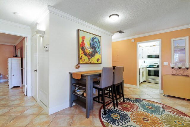 tiled dining area with crown molding and a textured ceiling