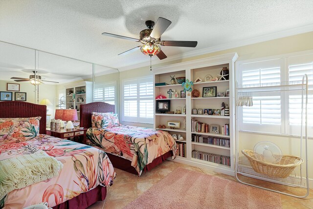 bedroom featuring ceiling fan, ornamental molding, a textured ceiling, and light tile patterned floors