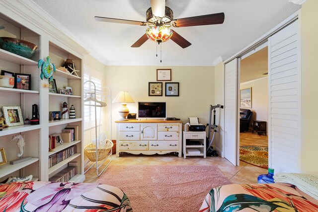 sitting room with light tile patterned floors, crown molding, a textured ceiling, and ceiling fan