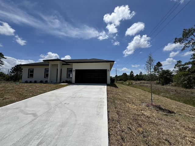 view of front of house featuring a garage, driveway, and stucco siding