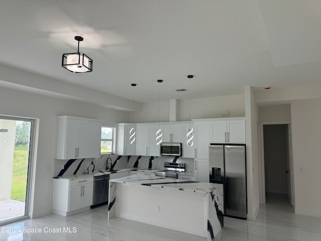 kitchen with stainless steel appliances, white cabinetry, decorative light fixtures, and decorative backsplash