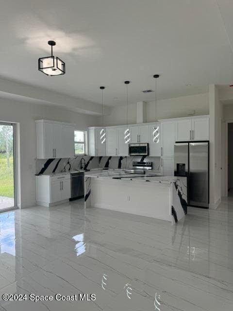 kitchen with stainless steel appliances, marble finish floor, white cabinets, and pendant lighting