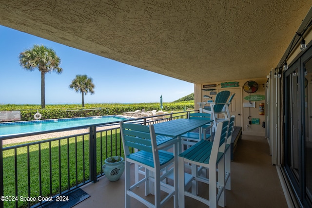 balcony featuring a fenced in pool